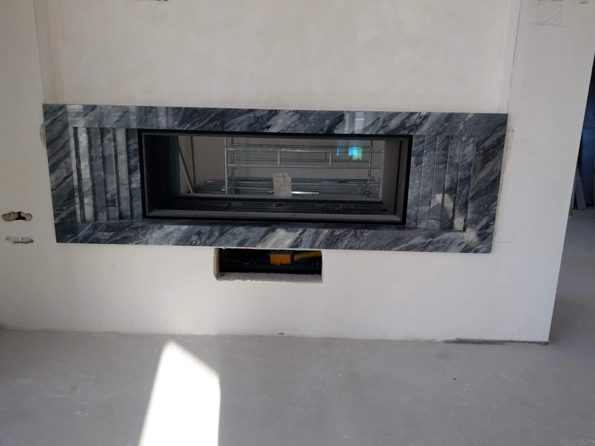 Camino con cornice in Bardiglio grigio venato, in cantiere