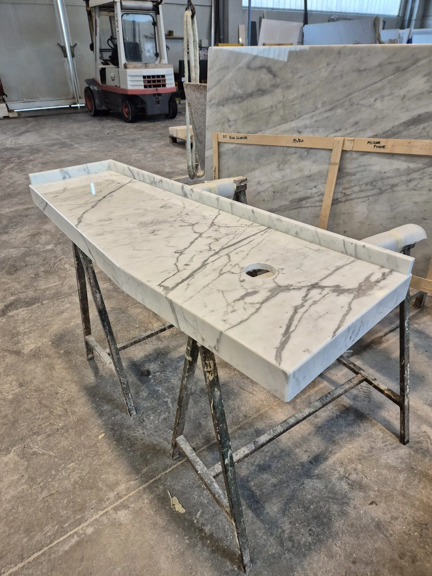 Top in marmo tipo Statuario tagliato su misura, sul cavalletto in laboratorio