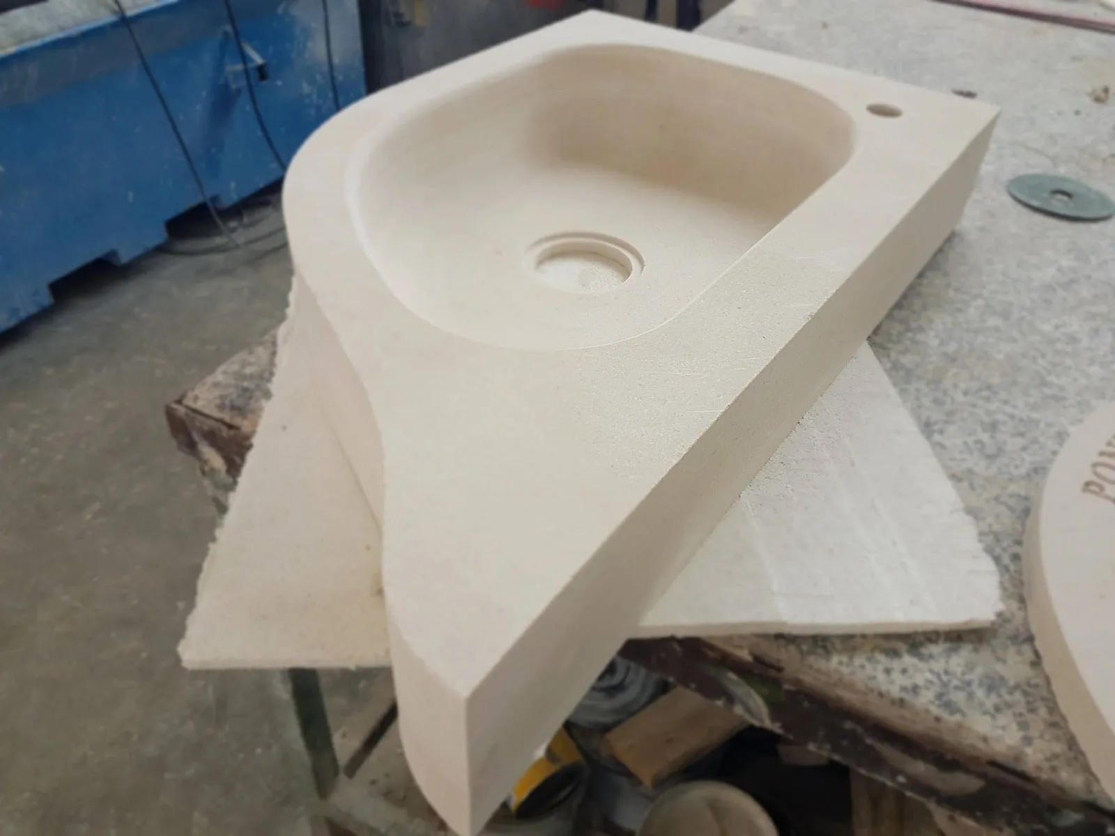 Aus einem massiven Steinblock gehöhltes Waschbecken, in der Werkstatt