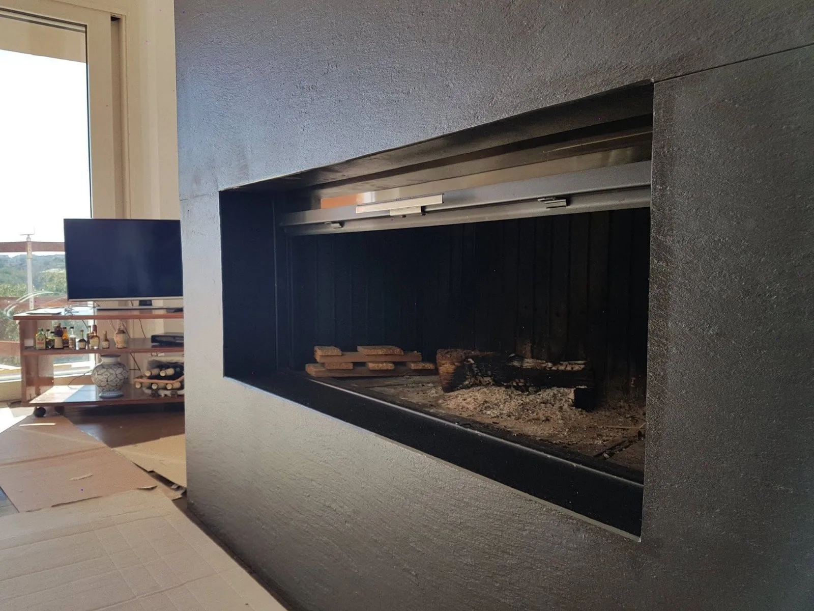 Moderner Kamin in dunklem, geschliffenem Stein
