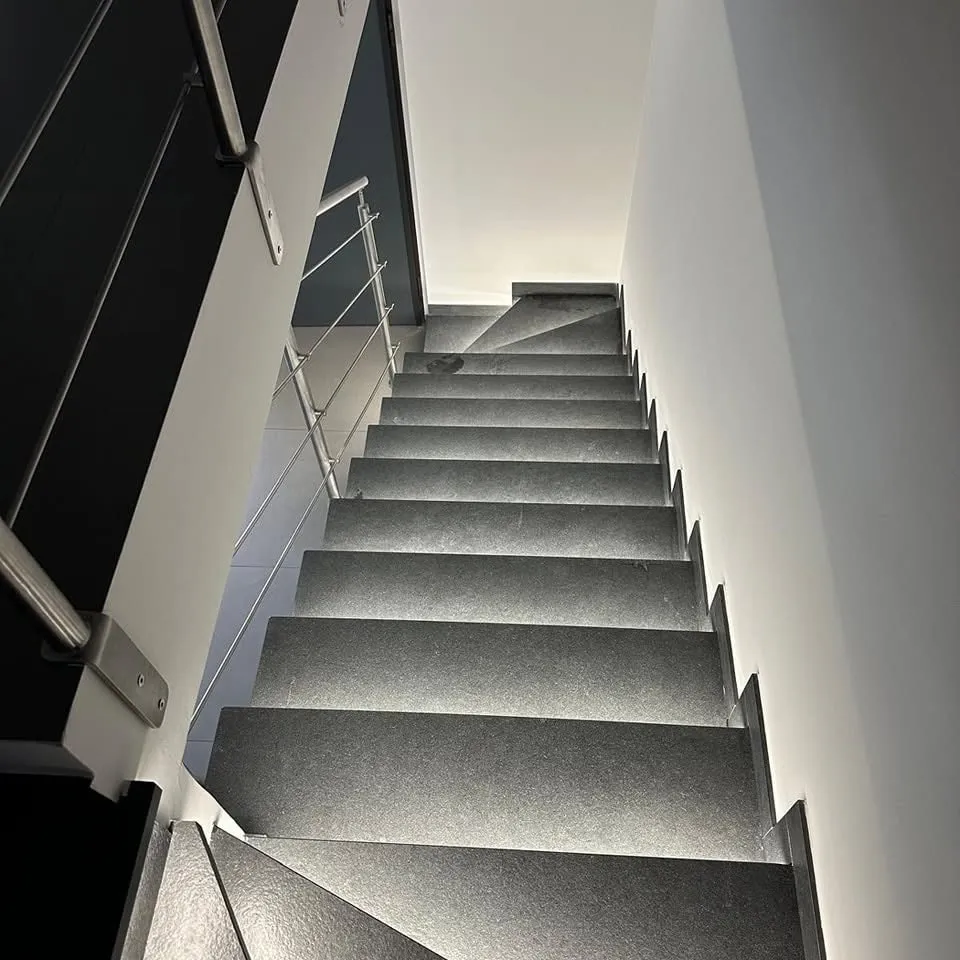 Escalier en pierre sombre sous lumière rasante