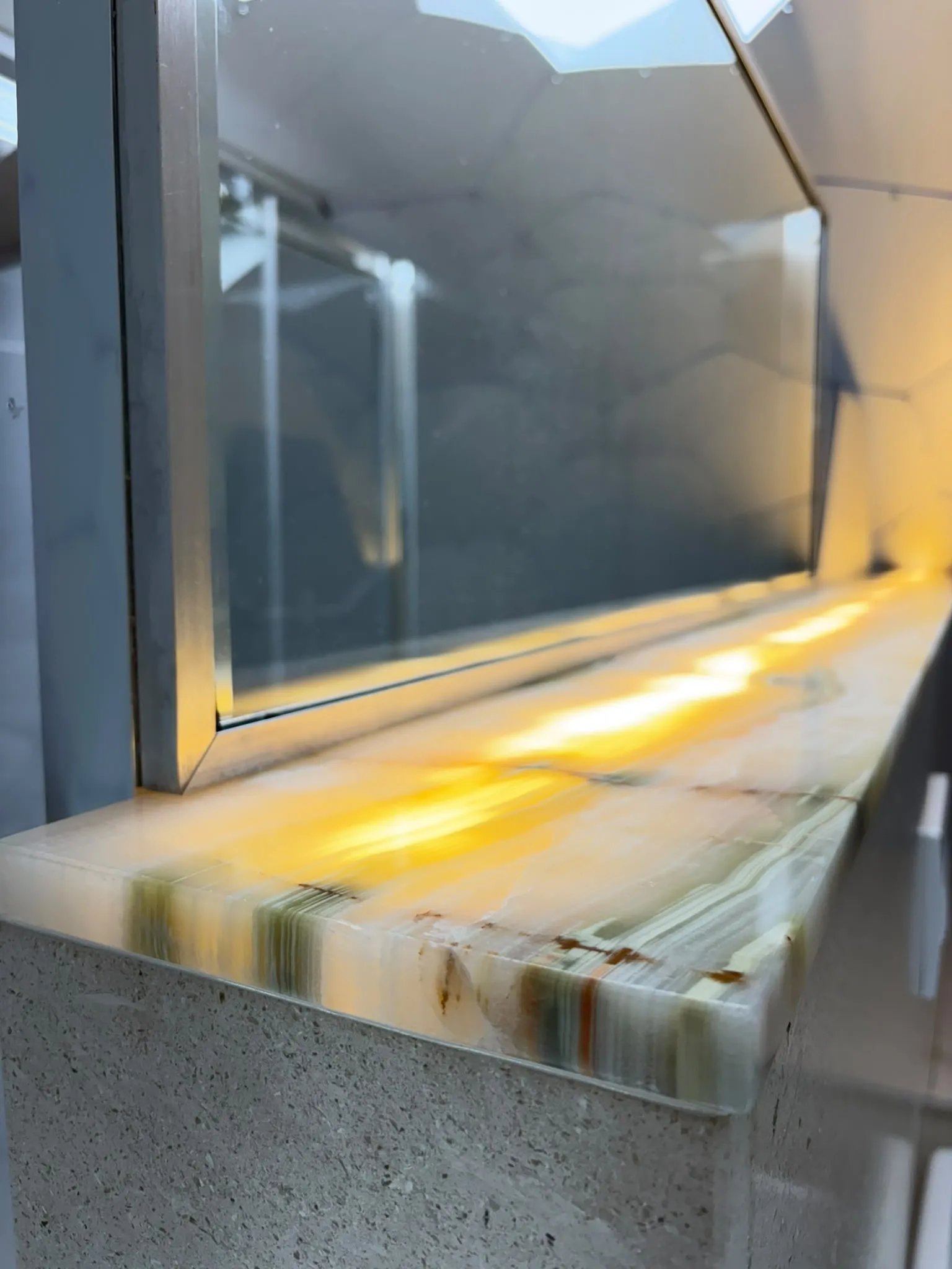 Backlit onyx shelf in front of the glazing