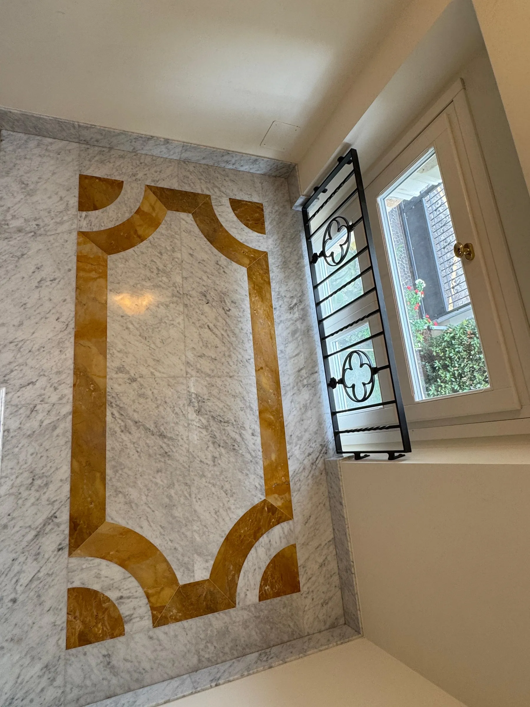 Pavimento in Bianco Carrara con riquadro in Giallo Siena davanti alla finestra