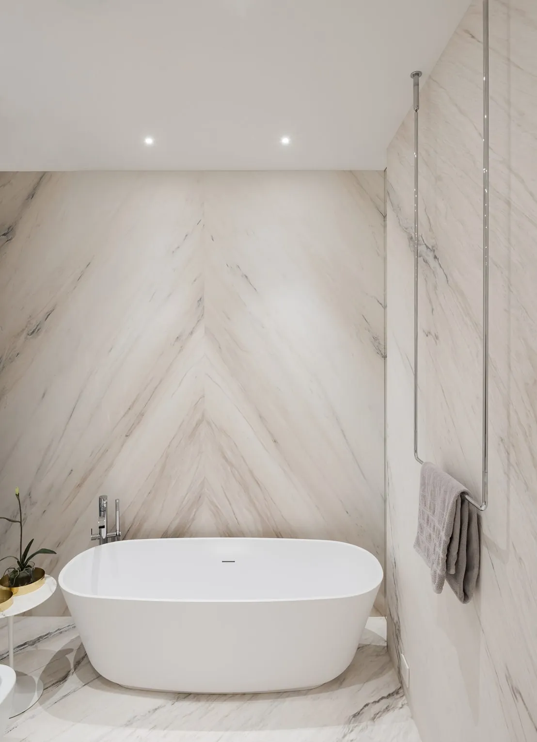 Wall of book-matched white marble slabs behind the bathtub