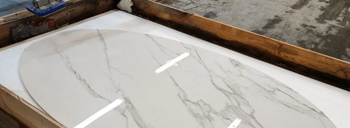 Statuario slab with the oval outline of a top traced from the template